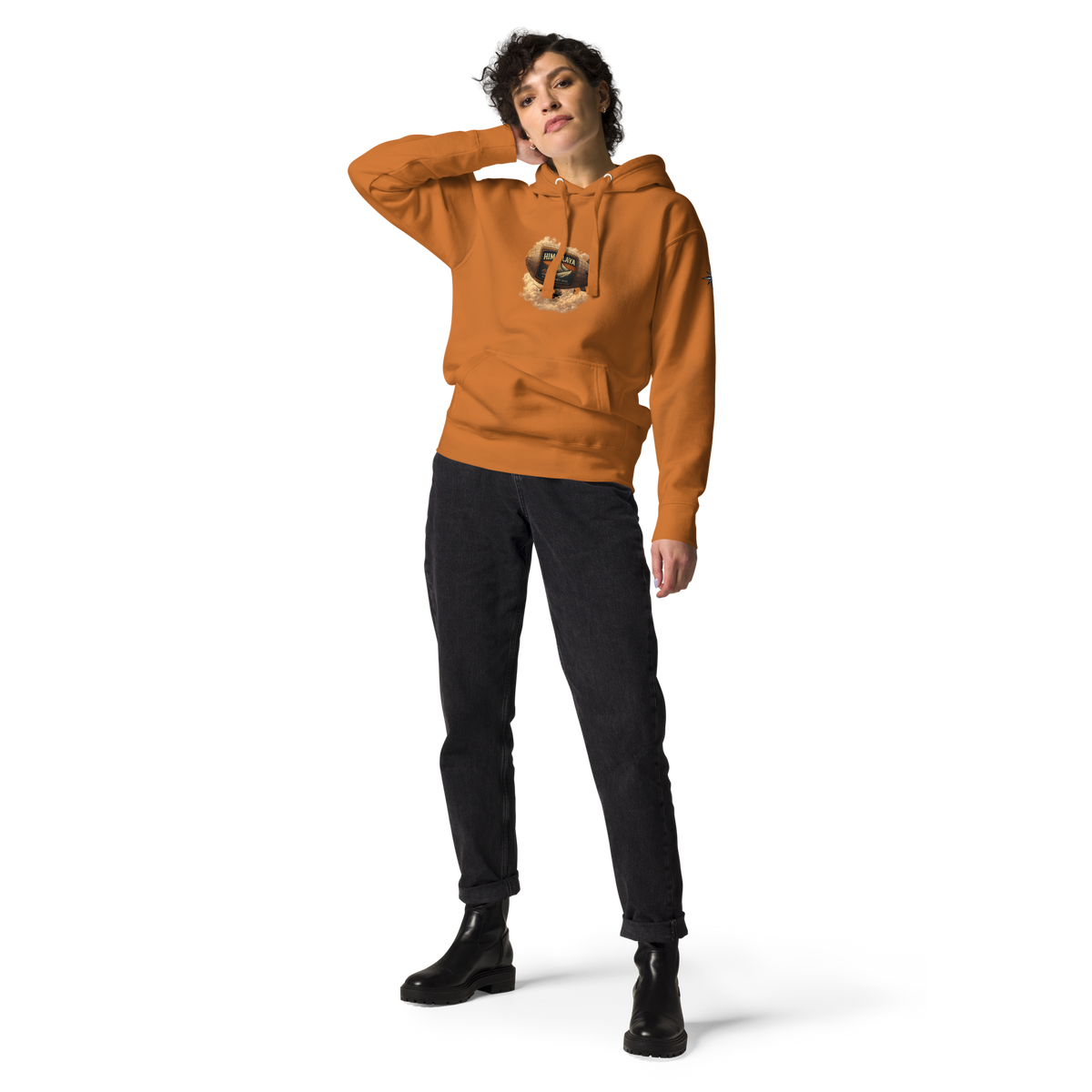 Person wearing an orange hoodie with a HIMAPLAYA logo on the chest , black jeans and boots